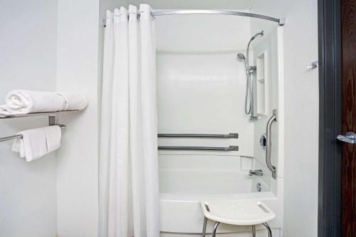 a bathroom with a white shower curtain and a toilet at Economy 7 Inn Chesapeake - Portsmouth in Chesapeake