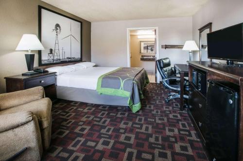 a hotel room with a bed and a desk at Super 8 by Wyndham Oklahoma Airport Fairgrounds West in Oklahoma City