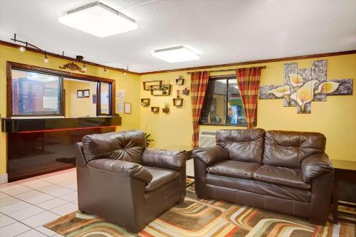 a living room with two leather chairs and a piano at Economy 7 Inn Chesapeake - Portsmouth in Chesapeake