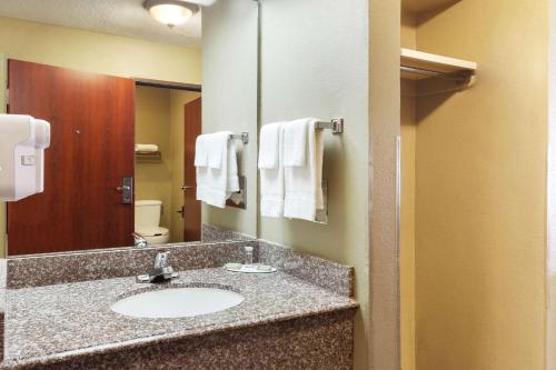 a bathroom with a sink and a mirror at Super 8 by Wyndham Sulphur in Sulphur