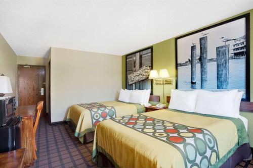 a hotel room with two beds and a tv at Economy 7 Inn Chesapeake - Portsmouth in Chesapeake