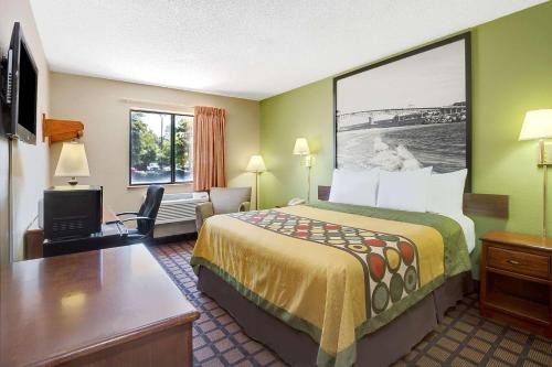 a hotel room with a bed and a desk and a tv at Economy 7 Inn Chesapeake - Portsmouth in Chesapeake