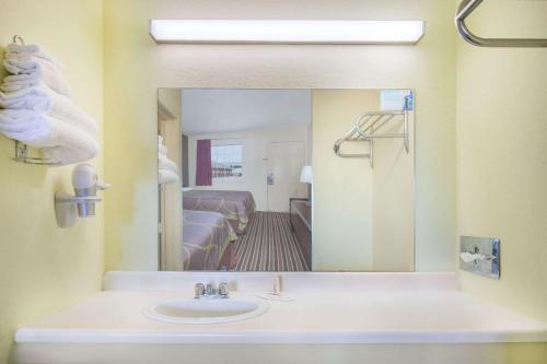 a bathroom with a sink and a mirror at Super Stay Inn And Suites in Muskogee