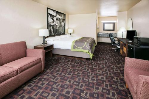 a hotel room with a bed and a desk at Super 8 by Wyndham Oklahoma Airport Fairgrounds West in Oklahoma City
