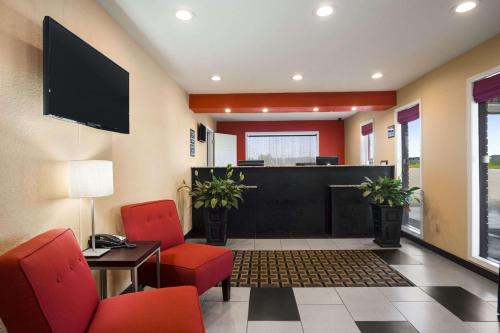 a waiting room with red chairs and a lobby at Super 8 by Wyndham Henryetta in Henryetta