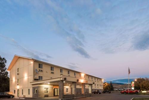 a large white building with a cloudy sky behind it at Super 8 by Wyndham Missoula/Reserve St. in Missoula
