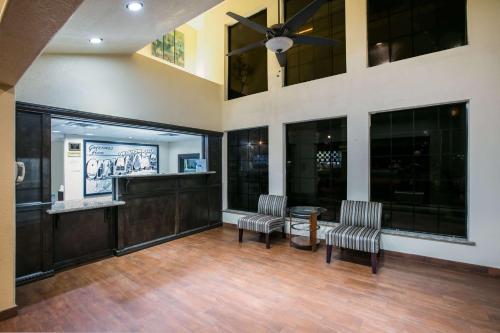 a large room with two chairs and a ceiling fan at Super 8 by Wyndham Oklahoma Airport Fairgrounds West in Oklahoma City