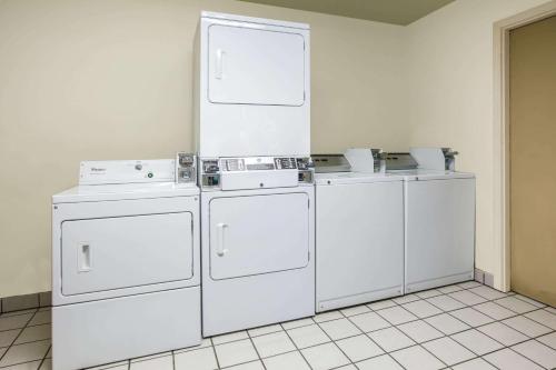 a row of white washing machines in a room at Super 8 by Wyndham Oklahoma Airport Fairgrounds West in Oklahoma City