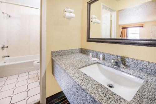 a bathroom with a sink and a mirror at Super 8 by Wyndham Tulsa/Arpt/St Fairgrounds in Tulsa