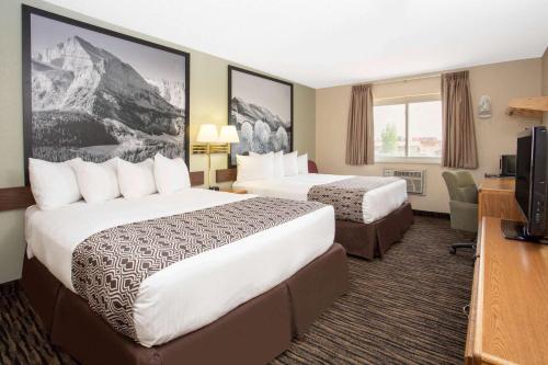 a hotel room with two beds and a television at Super 8 by Wyndham Lewistown in Lewistown