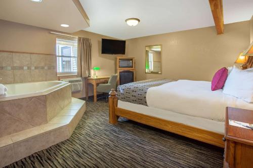 a hotel room with a bed and a bath tub at Super 8 by Wyndham Lewistown in Lewistown