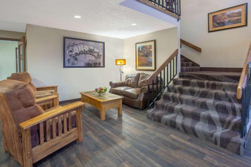 a living room with a staircase and a couch and chair at Super 8 by Wyndham Lewistown in Lewistown
