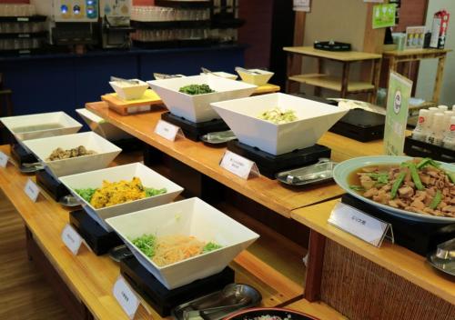 a buffet line with bowls of different types of food at Uomisaki Hotel in Atami