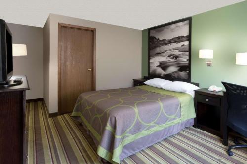 a hotel room with a bed and a flat screen tv at Super 8 by Wyndham Green River in Green River