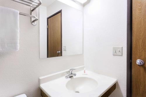 a white bathroom with a sink and a mirror at Super 8 by Wyndham Dumfries/Quantico in Dumfries