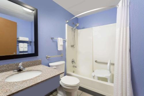 a bathroom with a toilet and a sink and a shower at Super 8 by Wyndham Douglas in Douglas