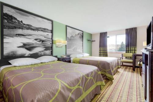 2 Betten in einem Hotelzimmer mit grünen Wänden in der Unterkunft Super 8 by Wyndham Green River in Green River