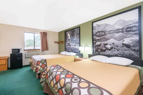 a hotel room with two beds and a large screen at Super 8 by Wyndham Buffalo in Buffalo