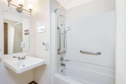a white bathroom with a sink and a shower at Super 8 by Wyndham Buffalo in Buffalo
