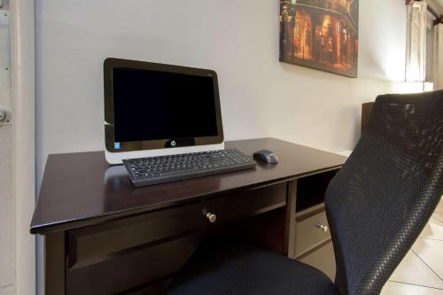 a laptop computer sitting on a desk with a chair at Super 8 by Wyndham West Monroe in West Monroe