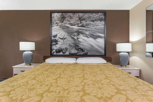a bedroom with a large bed with two lamps at Super 8 by Wyndham Shelton in Shelton