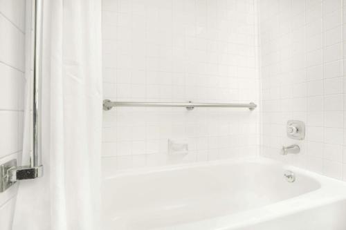 y baño blanco con bañera y ducha. en Super 8 by Wyndham Riverton, en Riverton