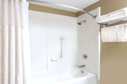 a bathroom with a shower and a white tub at Super 8 by Wyndham Logansport in Logansport