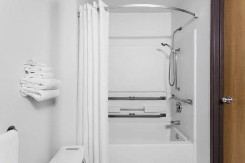 a white bathroom with a shower and a toilet at Super 8 by Wyndham Dumfries/Quantico in Dumfries