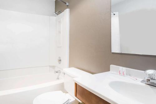 a bathroom with a sink and a toilet and a mirror at Super 8 by Wyndham Bremerton in Bremerton
