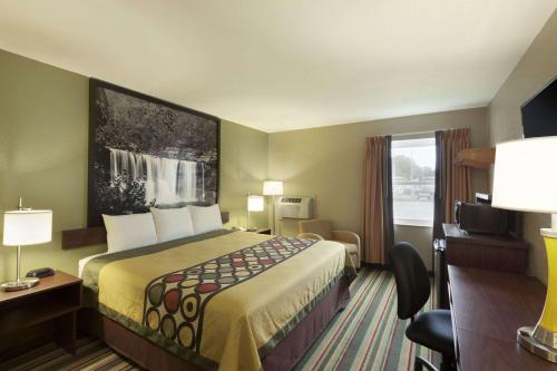 a hotel room with a large bed and a window at Super 8 by Wyndham Tuscola in Tuscola