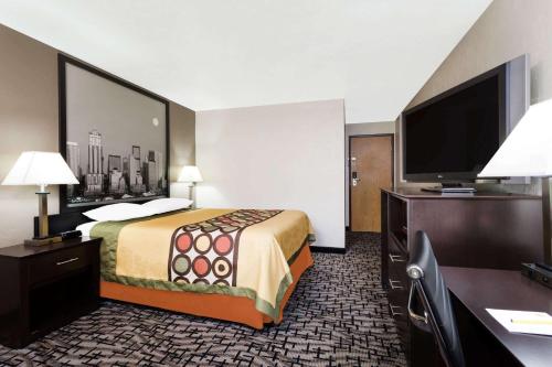 a hotel room with a bed and a flat screen tv at Super 8 by Wyndham Bremerton in Bremerton