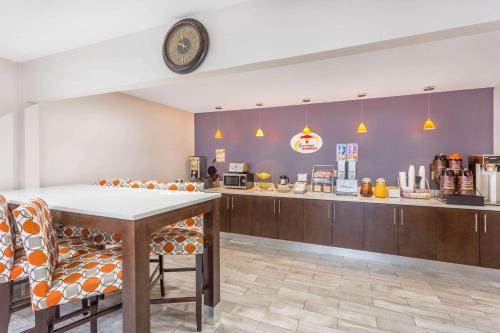 a restaurant with a table and chairs and a counter at Super 8 by Wyndham Locust Grove in Locust Grove