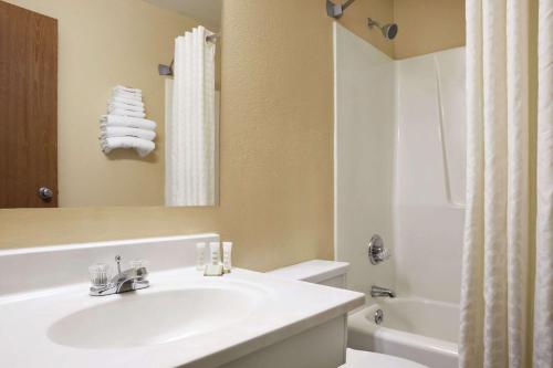 a bathroom with a sink and a toilet and a mirror at Super 8 by Wyndham Salem in Salem