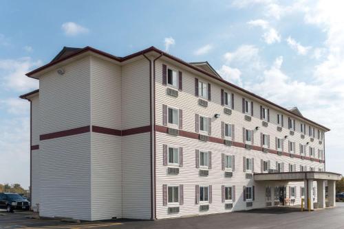a large white building with a gambrel roof at Super 8 by Wyndham Springfield East in Springfield