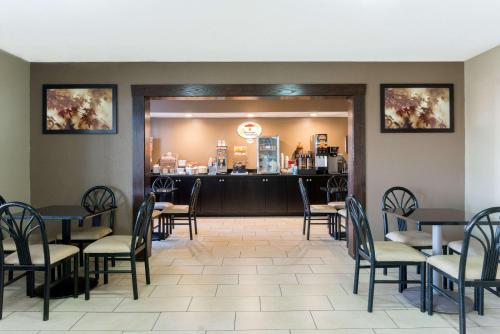 a dining room with tables and chairs and a counter at Super 8 by Wyndham Springfield East in Springfield