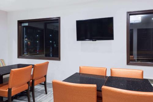 a conference room with tables and chairs and a flat screen tv at Super 8 by Wyndham Locust Grove in Locust Grove
