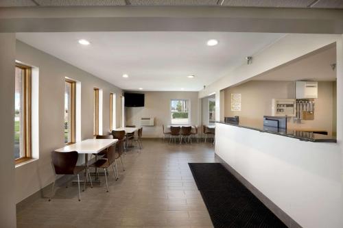 a hallway with tables and chairs in a building at Super 8 by Wyndham Tuscola in Tuscola