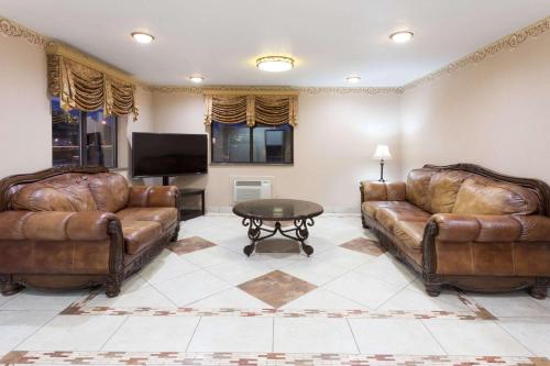 a living room with two leather couches and a table at Super 8 by Wyndham Rock Falls Sterling Area in Rock Falls