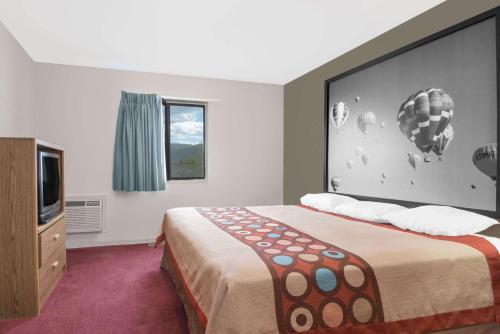 a bedroom with a large bed and a tv at Super 8 by Wyndham Taos in Taos