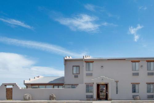 a white building with a blue sky in the background at Super 8 by Wyndham Taos in Taos