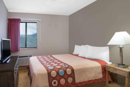 a hotel room with a bed and a window at Super 8 by Wyndham Taos in Taos