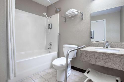 La salle de bains est pourvue de toilettes, d'un lavabo et d'une baignoire. dans l'établissement Super 8 by Wyndham Sherman, à Sherman