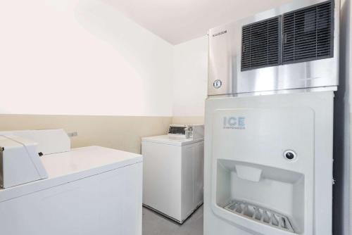 a kitchen with a refrigerator and a washer and dryer at Super 8 by Wyndham Fernley in Fernley