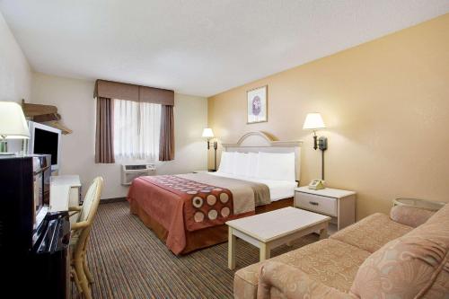 a hotel room with a bed and a couch at Super8 by Wyndham NEARBY Clearwater St Petersburg International Airport in Clearwater