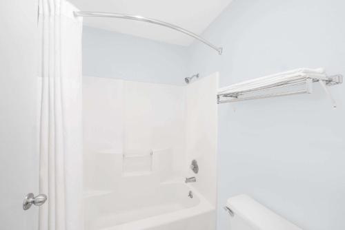 baño blanco con ducha y lavamanos en Super 8 by Wyndham Van Horn, en Van Horn