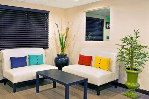 two chairs with colorful pillows and a table at Super 8 by Wyndham Ogden, Utah in Ogden