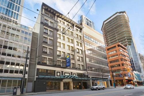 a tall building on a city street with buildings at Days Inn by Wyndham Vancouver Downtown in Vancouver