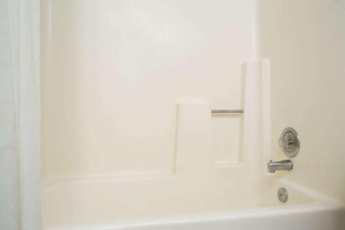 a white bath tub with a faucet in a bathroom at Super 8 by Wyndham Ogden, Utah in Ogden