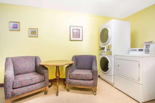Habitación con 2 sillas, mesa y lavadora. en Super 8 by Wyndham Elko, en Elko