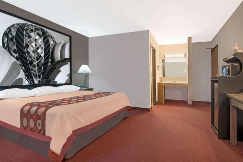a hotel room with a large bed and a desk at Super 8 by Wyndham Taos in Taos
